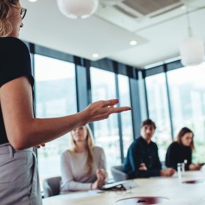 Businesswoman making a presentation to her colleagues in office. Office colleagues sitting at the conference room while listening to a presentation.